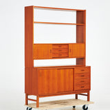 TEAK BOOKCASE. A mid-20th century, teak, two-piece, lower cabinet with drawers.