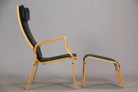 Side View of Black Leather Beech Armchair and Footstool