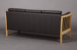 Three-person  sofa in oak with loose cushions.