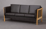 Three-person  sofa in oak with loose cushions.