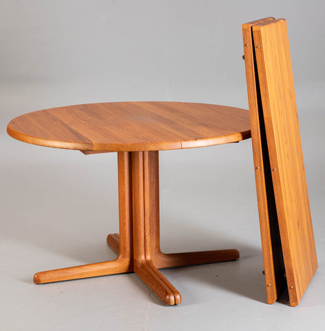 Solid teak pedestal dining table with two leaves.